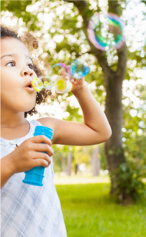 child blowing bubbles